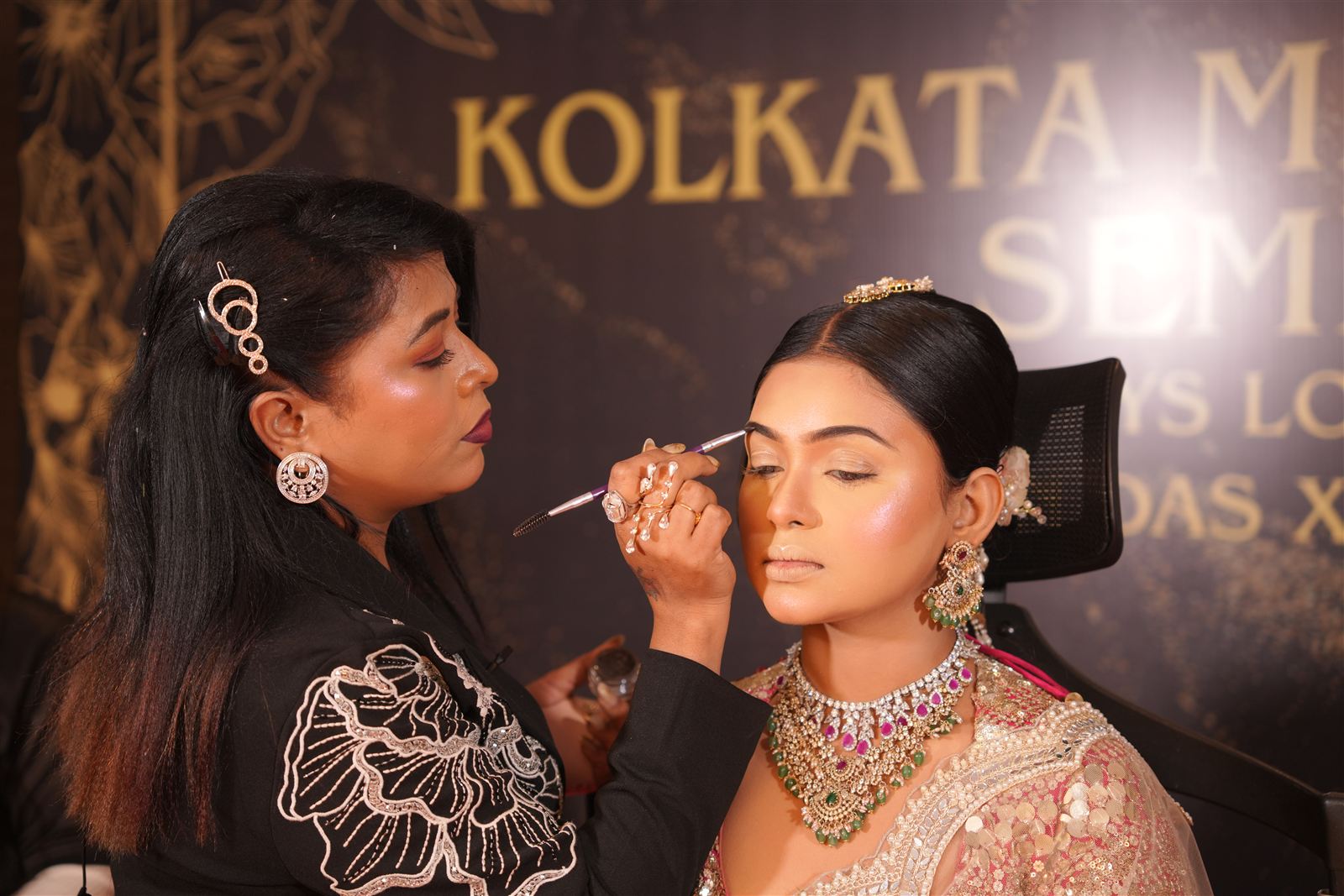 Artist demonstrating eye makeup on a model during a live demo